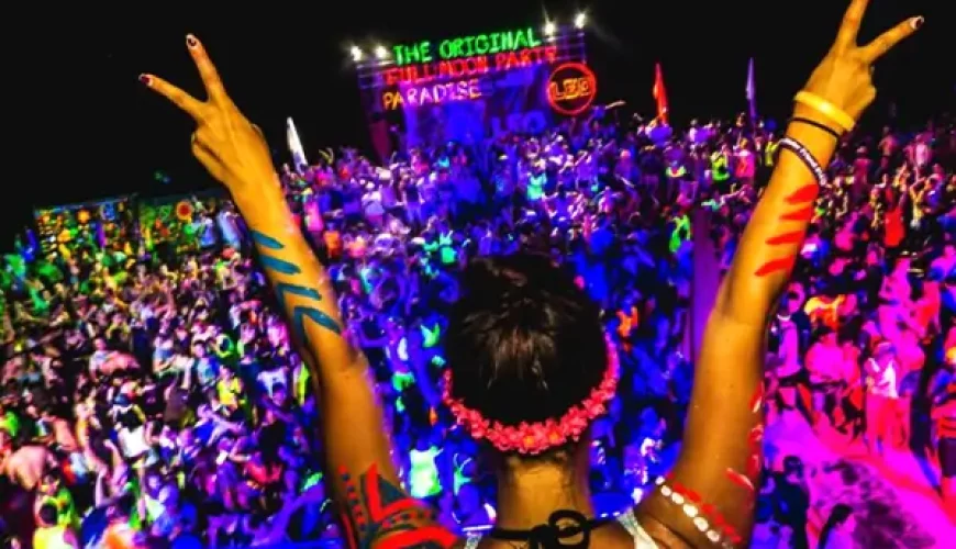 Crowd enjoying vibrant Full Moon Party in Koh Phangan with neon lights, music stage, and dancing atmosphere – Thailand nightlife festival