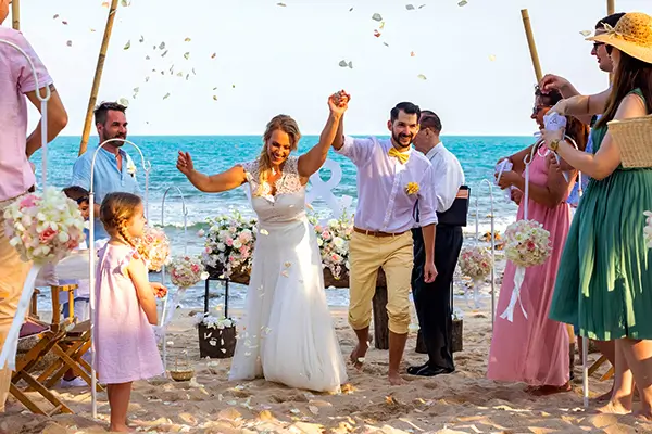 Beachfront wedding ceremony in Koh Samui with bride and groom celebrating – dream destination wedding in Thailand.